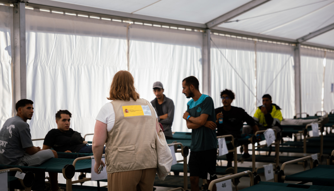 Un grupo de inmigrantes que han sido realojados desde las playas de Benítez y el Trampolín de Ceuta al campamento temporal habilitado en el puerto de la ciudad