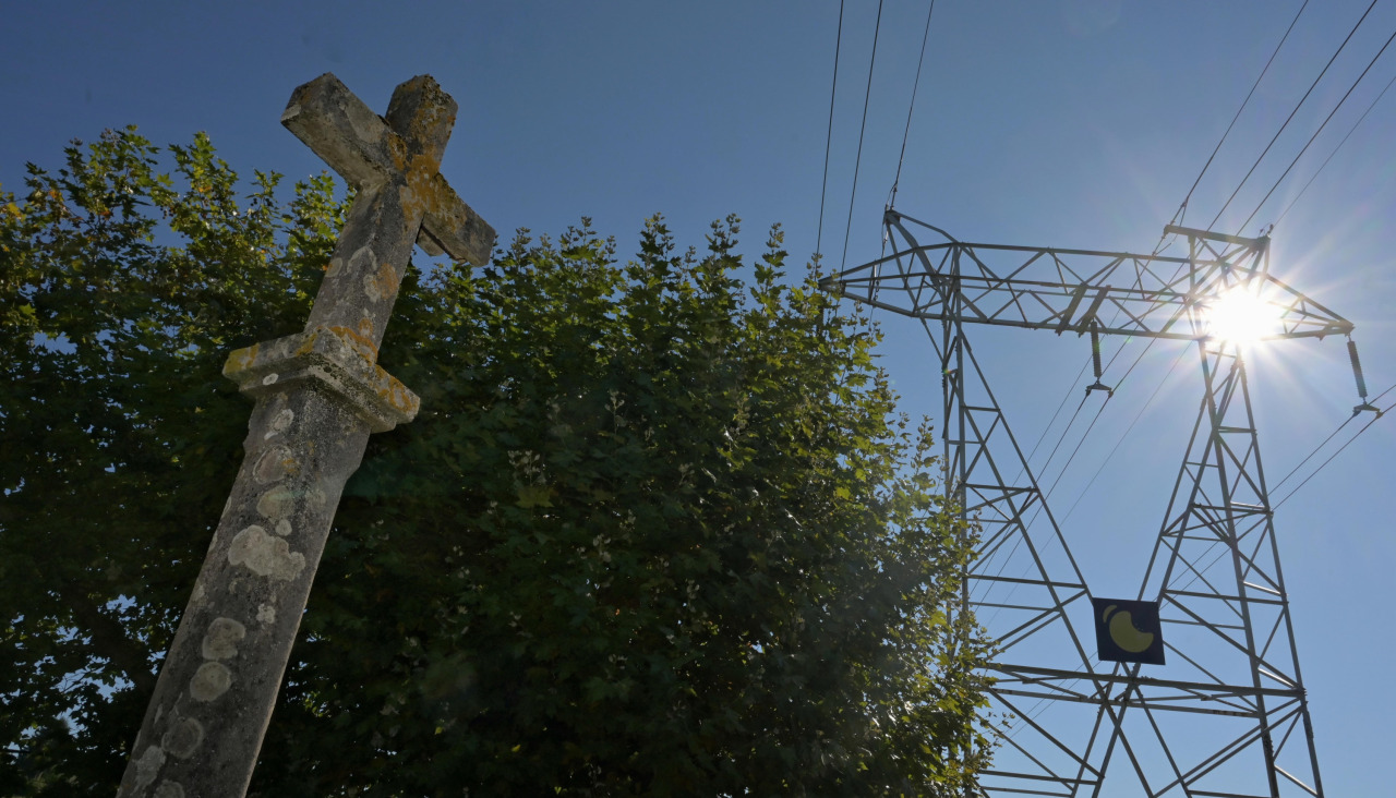 Cruceiro y torre de alta tensión situadas en las inmediaciones del Mosteiro de San Salvador