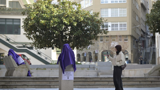 Una mujer fotografia algunas de las estatuas cubiertas, esta mañana, en la plaza del Humor