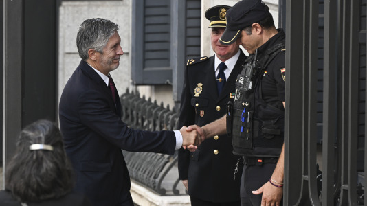 El ministro del Interior, Fernando Grande-Marlaska (i), saluda a un agente de Policía Nacional a su llegada al Congreso de los diputados donde el papa León XIV pronuncia este lunes un esperado e histórico discurso en las Cortes durante su visita a España
