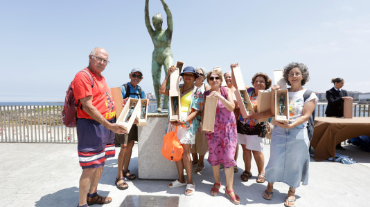 El grupo de jubilados conocido como Los Golfiños que desde hace años se reúnen en Riazor para bañarse en la playa, recibió la mañana de este martes un homenaje: Valentina; una figura de bronce que desde el Paseo Marítimo invita a tomar un baño en el mar