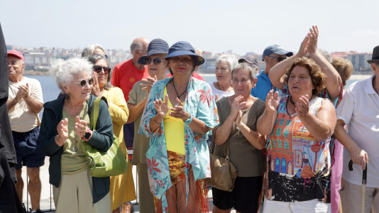 El grupo de jubilados conocido como Los Golfiños que desde hace años se reúnen en Riazor para bañarse en la playa, recibió la mañana de este martes un homenaje: Valentina; una figura de bronce que desde el Paseo Marítimo invita a tomar un baño en el mar