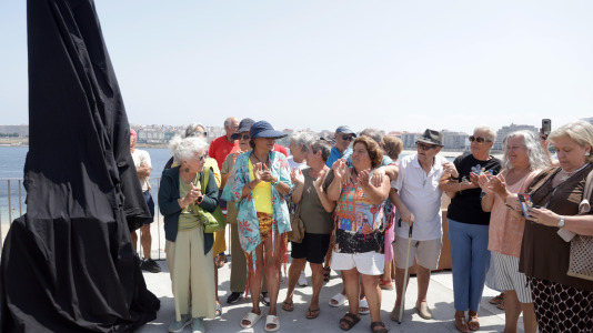 El grupo de jubilados conocido como Los Golfiños que desde hace años se reúnen en Riazor para bañarse en la playa, recibió la mañana de este martes un homenaje: Valentina; una figura de bronce que desde el Paseo Marítimo invita a tomar un baño en el mar