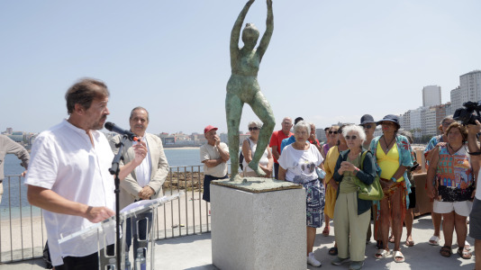 El grupo de jubilados conocido como Los Golfiños que desde hace años se reúnen en Riazor para bañarse en la playa, recibió la mañana de este martes un homenaje: Valentina; una figura de bronce que desde el Paseo Marítimo invita a tomar un baño en el mar