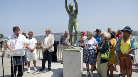 El grupo de jubilados conocido como Los Golfiños que desde hace años se reúnen en Riazor para bañarse en la playa, recibió la mañana de este martes un homenaje: Valentina; una figura de bronce que desde el Paseo Marítimo invita a tomar un baño en el mar
