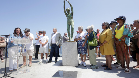 El grupo de jubilados conocido como Los Golfiños que desde hace años se reúnen en Riazor para bañarse en la playa, recibió la mañana de este martes un homenaje: Valentina; una figura de bronce que desde el Paseo Marítimo invita a tomar un baño en el mar